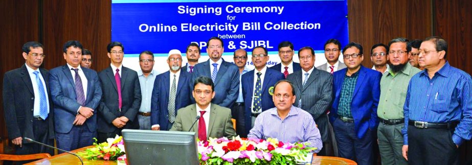 Mohammad Munir Chowdhury, Deputy Secretary of Dhaka Power Distribution Company and M Mushfiquir Rahman, Senior Executive Vice President of Shahjalal Islami Bank Ltd, sign an agreement of Online Electricity Bill Collection system for the clients of Dhaka a
