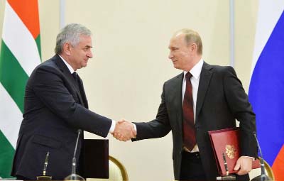 Russian President Vladimir Putin, right, and leader of Georgia's breakaway province of Abkhazia Raul Khadzhimba shake hands at a signing ceremony in the Bocharov Ruchei residence in Sochi, Russia on Monday