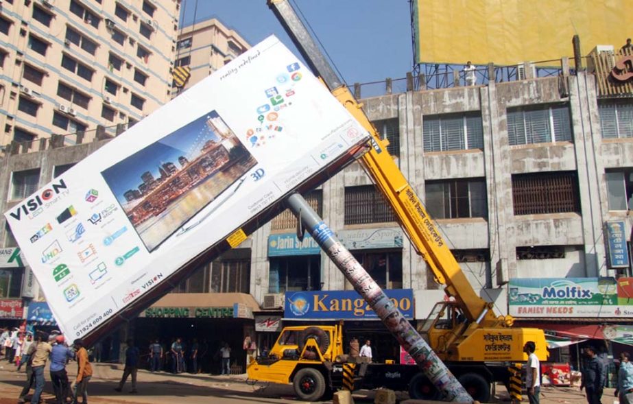 Illegal bill boards are being removed from Kazir Dewari area in the city yesterday.