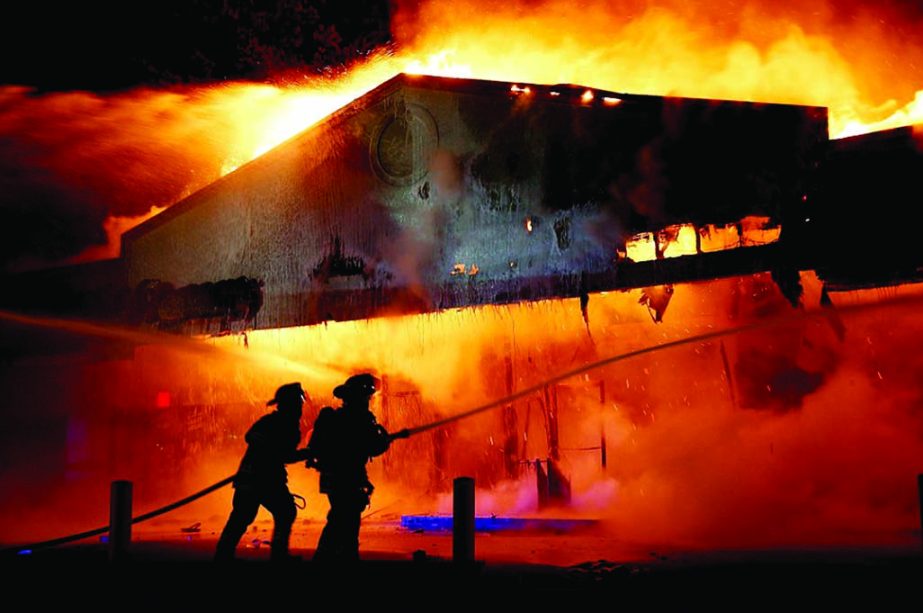 Firefighters work on extinguishing the burning Little Ceasar's restaurant in Ferguson-US on Monday night. Protestors taunted police, broke windows and vandalized cars. Internet photo