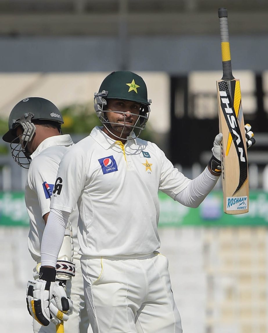 Pakistani batsman Mohammad Hafeez raises his bat after scoring a half century (50 runs) during the first day of the third and final Test match between Pakistan and New Zealand at the Sharjah cricket stadium in Sharjah on Wednesday.