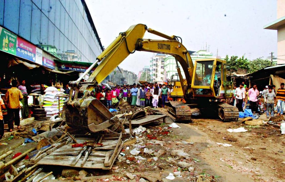 Illegal establishments in front of Mirpur-1 Kutcha Bazar area being bulldozed by DMP-led team on Sunday .