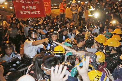 Police use pepper spray during clashes with pro-democracy protesters close to the chief executive office in Hong Kong, on Sunday.