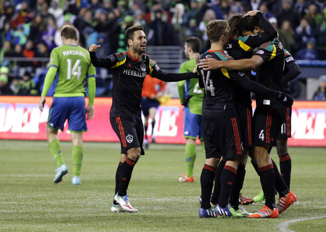 Los Angeles Galaxy players including Marcelo Sarvas (left) celebrate at the end of the second leg of the MLS western conference final soccer match in Seattle on Sunday. The match ended with a score of 2-1 in favour of the Sounders, but the Galaxy won the