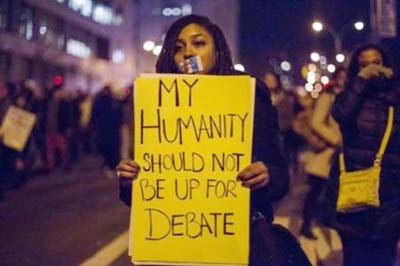 A female protester, demanding justice for Eric Garner, holds a placard in Brooklyn, New York