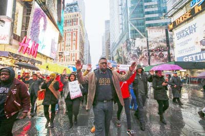 Demonstrators in New York City arrive at Times Square to protest against the recent decisions by grand juries in New York and Ferguson, Missouri, not to charge police officers involved in the deaths of two African-American men on Saturday.