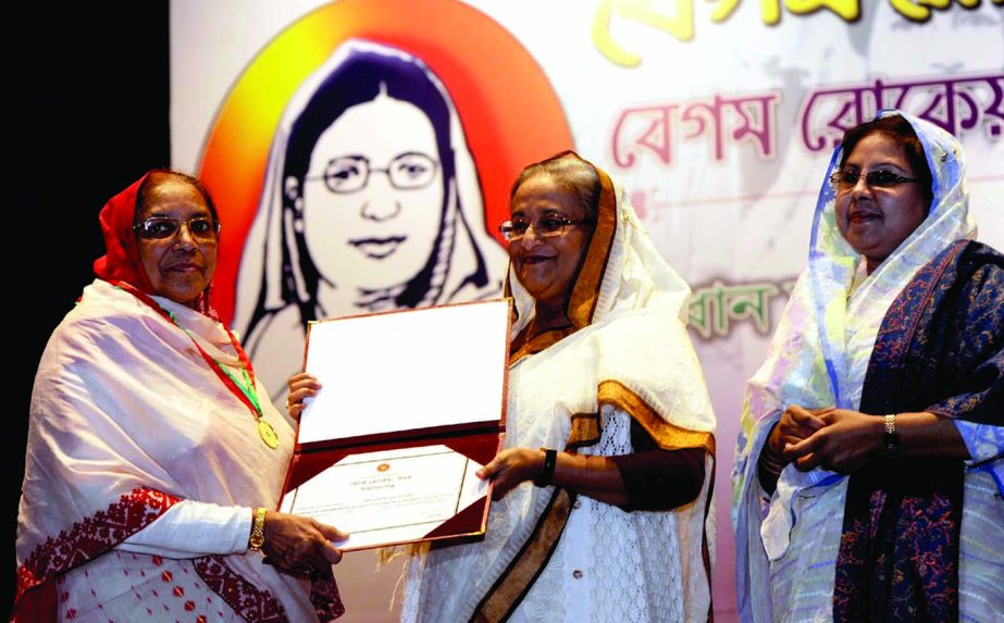 Prime Minister Sheikh Hasina handing over 'Begum Rokeya Padak-2014' to its winner Prof Mamtaz Begum at a ceremony at Osmani Memorial Auditorium in the city on Tuesday. BSS photo