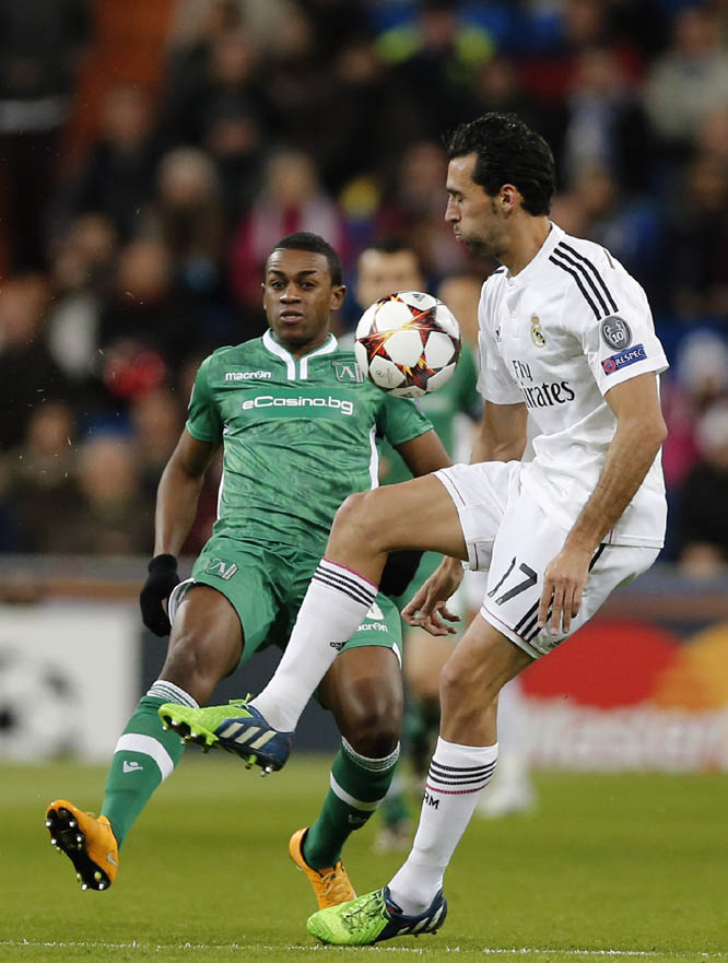 Real Madrid's Alvaro Arbeloa (right) fights for the ball with Ludogorets' Virgil Misidjan during a Group B Champions League soccer match between Real Madrid and Ludogorets at the Santiago Bernabeu Stadium in Madrid, Spain on Tuesday.