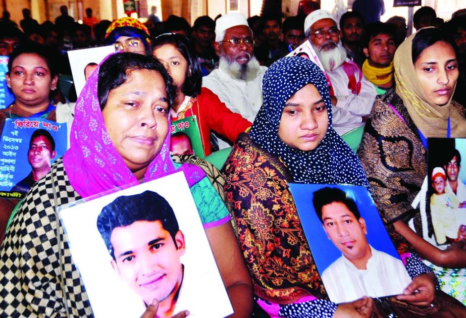 Family members displaying photos of the victims of forced disappearances at a discussion meeting organised by the Basic Rights Protection Committee marking the International Human Rights Day at the Jatiya Press Club on Wednesday.