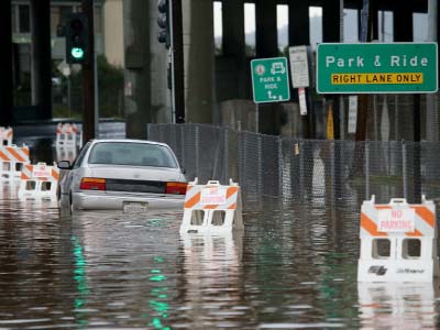 A car sits partially submerged in water on a flooded section of roadway in Mill Valley, California.