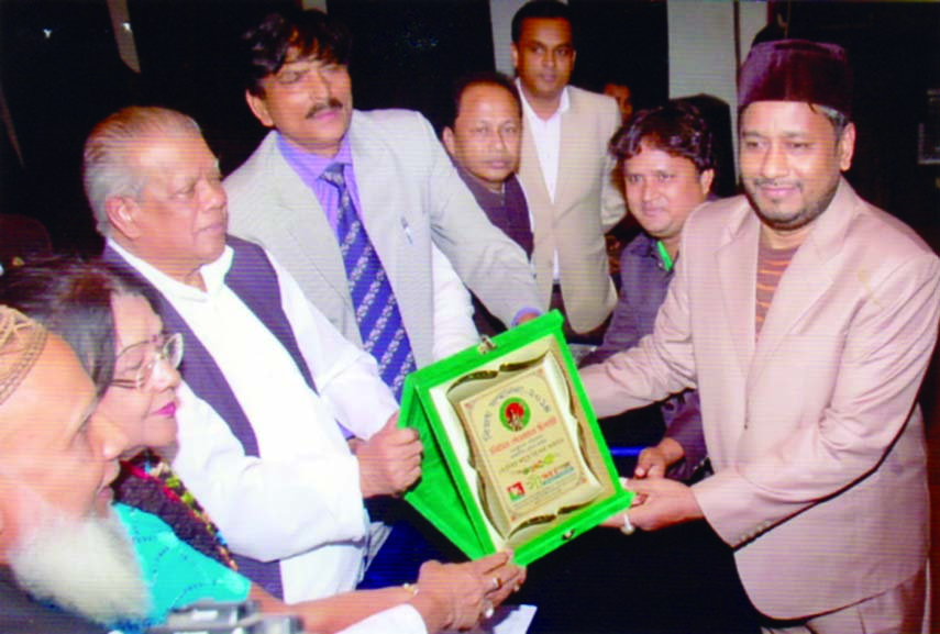 Industries Minister Amir Hossain Amu handing over medal to Liton Dewan Chisti for his contribution in astrological science at a discussion organised recently on Victory Day by Simanta Cultural Foundation at BMA auditorium in the city.