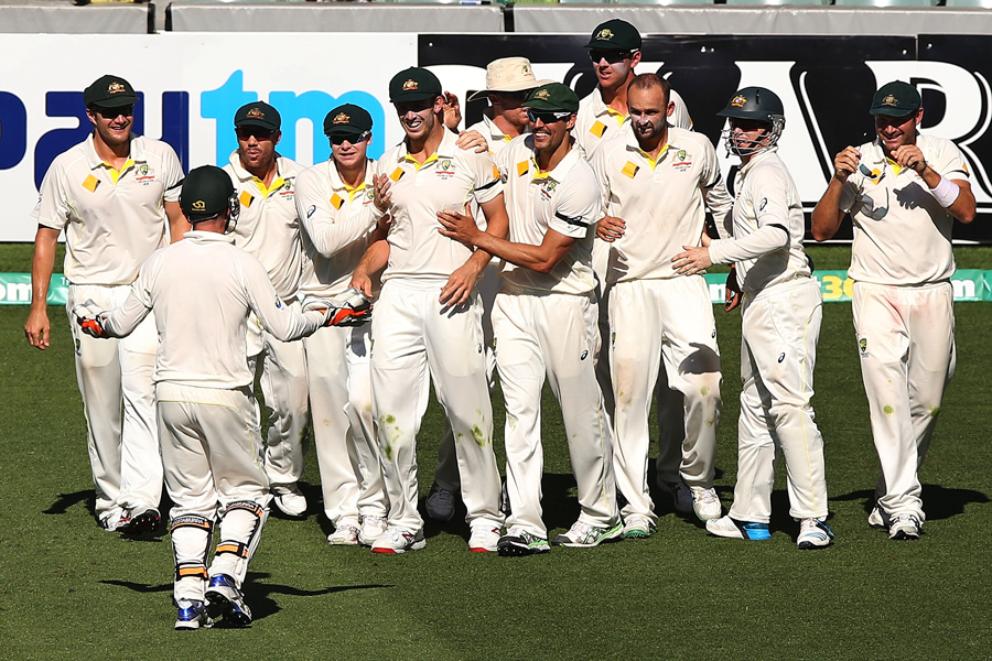 Players of Australia gather around Mitch Marsh after he completes the catch to dismiss Virat Kohli on the fifth day of the 1st Test between Australia and India at Adelaide on Saturday.