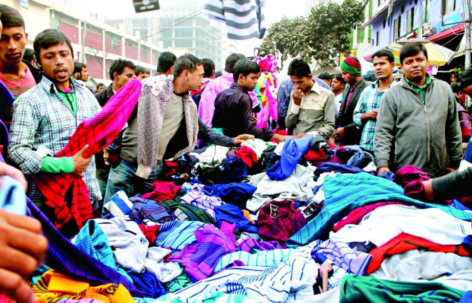People rush to buy warm clothes as biting cold wave sweeping the city and elsewhere. This photo was taken from Farmgate area on Saturday.