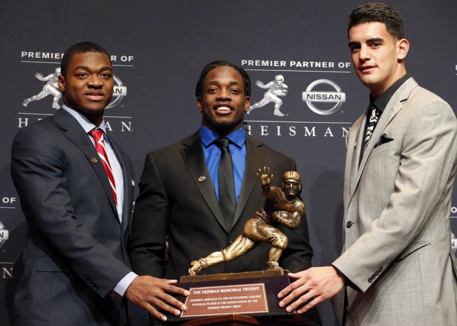 Heisman Trophy finalists Alabama receiver Amari Cooper (left) Wisconsin running back Melvin Gordon (center) and Oregon quarterback Marcus Mariota pose with the trophy during a news conference prior to the announcement of the winner in New York on Saturday