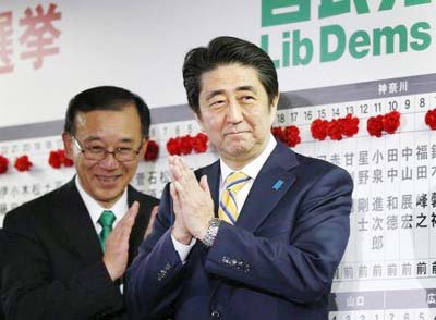 Japanese Prime Minister and ruling Liberal Democratic Party (LDP) leader Shinzo Abe acknowledges cheering supporters during his election campaign speech.