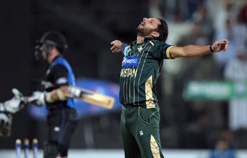 Pakistani captain and spinner Shahid Afridi (R) celebrates after taking the wicket of New Zealand batsman Luke Ronchi (L) during the third Day-Night International cricket match between Pakistan and New Zealand at the Sharjah cricket stadium in Sharjah on
