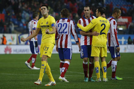 Villarreal's Bruno (left) celebrates the victory with team mates as Atletico's Diego Godin (centre right) hugs Villarreal's Mario (second right) during a Spanish La Liga soccer match between Atletico de Madrid and Villarreal at the Vicente Calderon sta