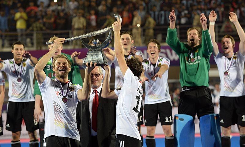 Germany hockey team captain Moritz Furste (2nd L) lifts the trophy as teammates cheer after defeating Pakistan during their Champions Trophy 2014 final match in Bhubaneswar on Sunday.