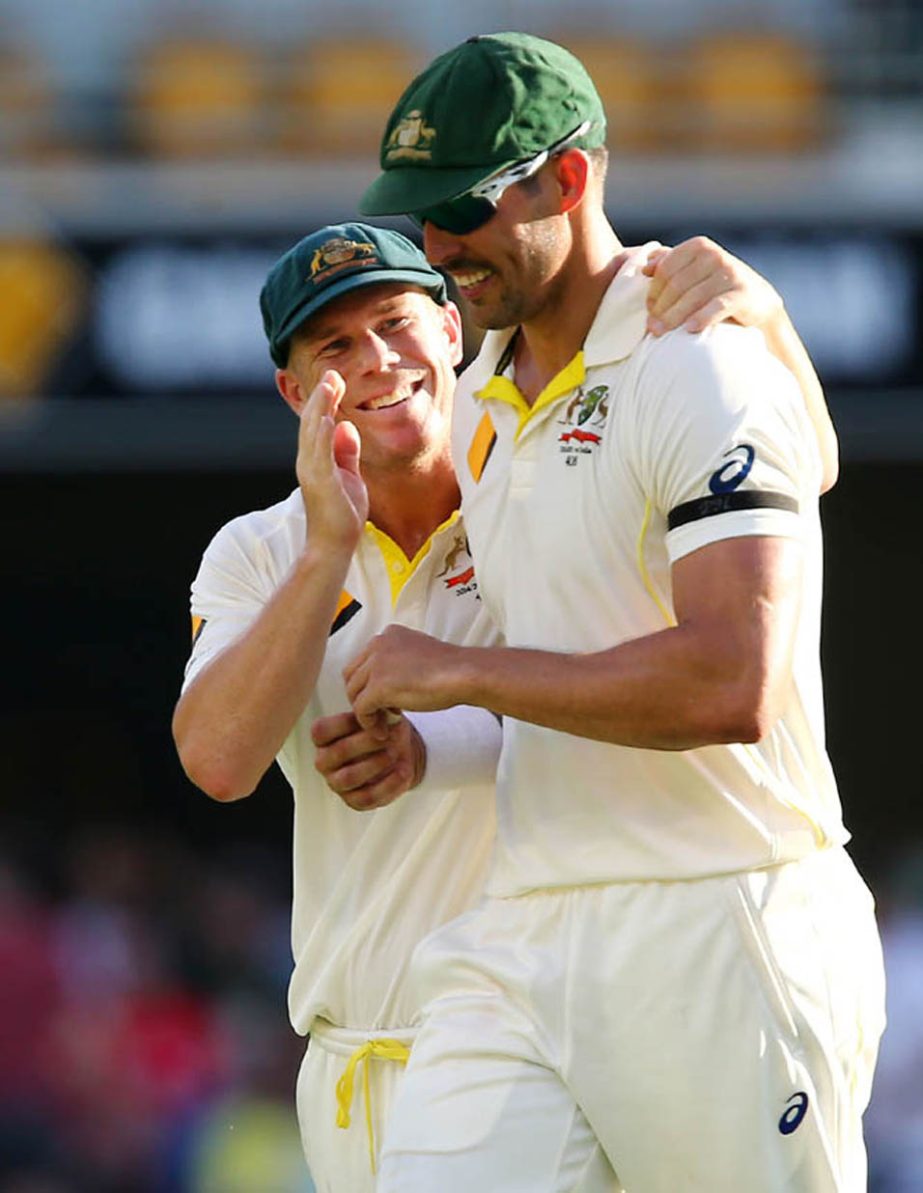 Australian players David Warner (left) and Mitchell Johnson talk during play on day one of the second cricket Test against India in Brisbane, Australia on Wednesday.