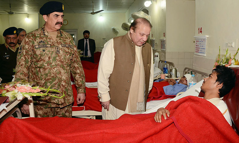 This handout picture released by Inter-Services Public Relation (ISPR) on December 17, 2014 shows Prime Minister Nawaz Sharif (C) chatting with an injured student from the Army Public School a day after militants attacked the school, at the military hospi