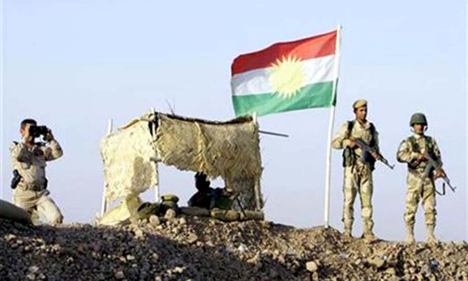 Kurdish Peshmerga soldiers look on at a guard post during a deployment in the area near the northern Iraqi border with Syria.