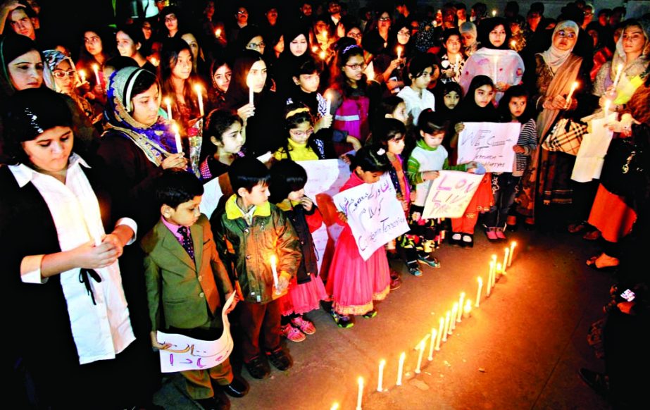 Pak nationals including their children condoled with candlelights the killings of school boys by Taliban at Peshawar four-day ago. This photo was taken from Pakistan Embassy premises on Friday.