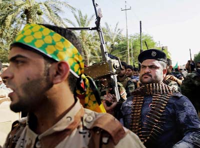 Shiâ€™ite tribal fighters raise their weapons and chant slogans against the al-Qaida-inspired Islamic State of Iraq and the Levant (ISIL), now called the Islamic State group, in Basra