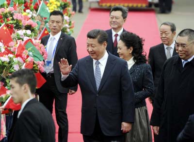 Chinese President Xi Jinping, centre, and his wife Peng Liyuan, centre right, wave as they arrive at the international airport in Macau, south China on Friday.