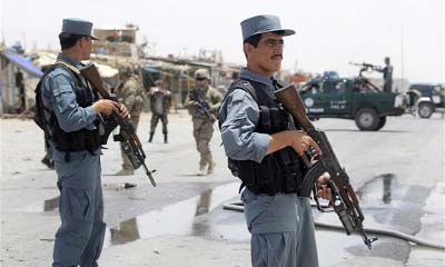 Afghan policemen stand guard at a bomb blast area near Kabul.