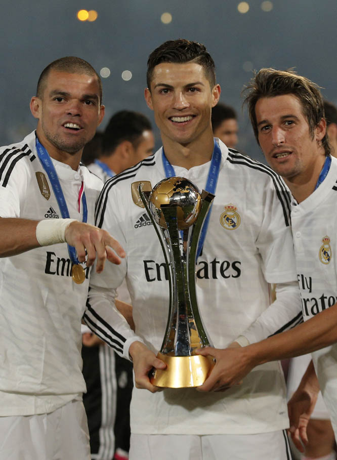 Real Madrid's Portuguese players Pepe (left) Cristiano Ronaldo, centre and Fabio Coentrao pose with the trophy during the final soccer match between Real Madrid and San Lorenzo at the Club World Cup soccer tournament in Marrakech, Morocco on Saturday.