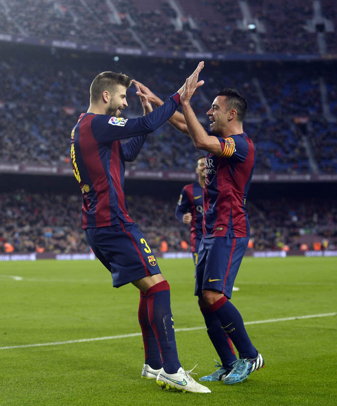 FC Barcelona's Gerard Pique (left) reacts after scoring against Cordoba with his teammate Xavi Hernandez during a Spanish La Liga soccer match at the Camp Nou stadium in Barcelona, Spain on Saturday.