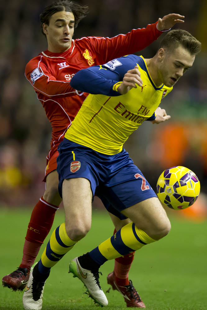 Liverpool's Lazar Markovic (left) fights for the ball against Arsenal's Calum Chambers during the English Premier League soccer match between Liverpool and Arsenal at Anfield Stadium, Liverpool, England on Sunday.