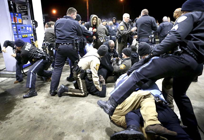 Police try to control a crowd on the lot of a gas station following a shooting on Tuesday in Berkeley.