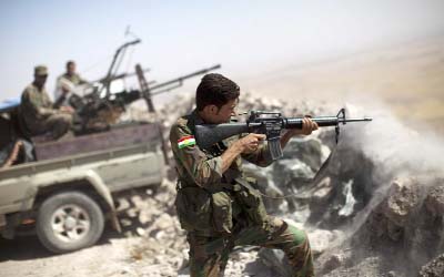 An Iraqi Kurdish Peshmerga fighter fires at Islamic-State (IS) militant positions, from his position on the top of Mount Zardak, a strategic point taken 3 days ago, about 25 kilometres east of Mosul .