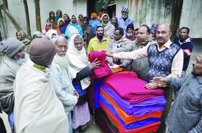 DINAJPUR: Dinajpur District Sramik League General Secretary Md Alauddin distributing warm clothes among the cold-hit people yesterday.