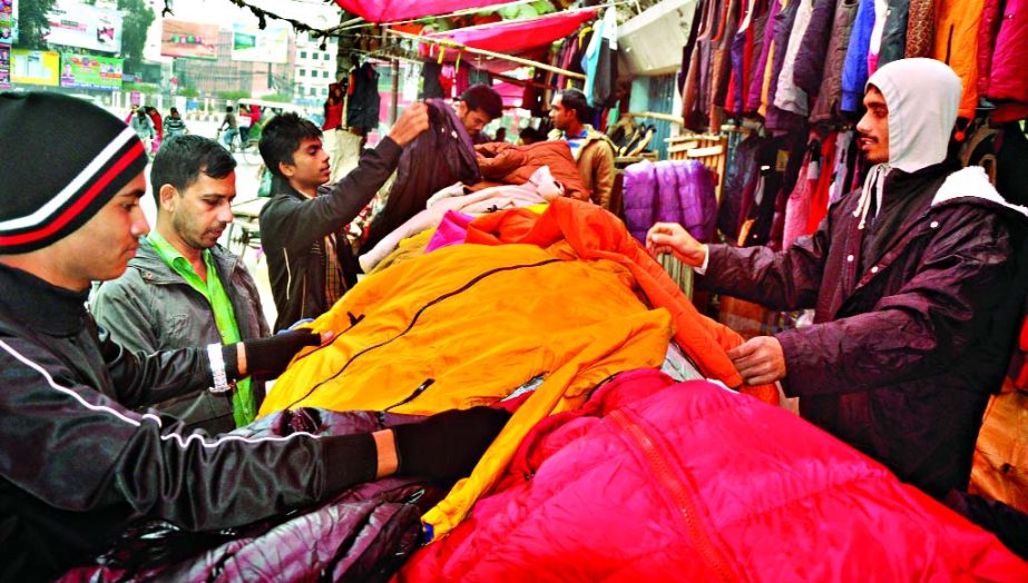 People rush to makeshift markets to buy warm clothes as bone-chilling cold continues from yesterday across the country. This photo was taken from Baitul Mukarram areas.