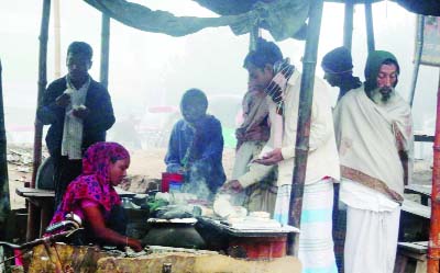 NARSINGDI: A women seen busy in making traditional winter cakes at Valanagur Jilkhana crossing in the town.