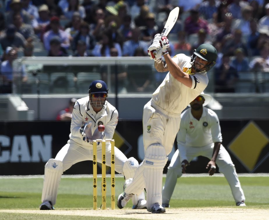 Australia's Mitchell Johnson (center) plays at a ball and misses allowing India's wicketkeeper MS Dhoni (left) to stump him for 28 runs on the second day of their cricket Test match in Melbourne, Australia on Saturday.