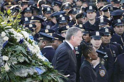 New York Mayor Bill de Blasio and wife Chirlane McCray walk past a sea of policemen while arriving for the funeral services of New York Police Department (NYPD) officer Rafael Ramos in the Queens borough of New York.