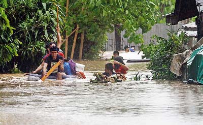 Residents help each other out from their inundated neighborhoods after flooding in southern Philippine island of Mindanao on Monday.