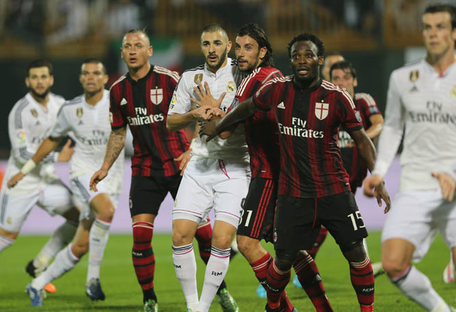 Real Madrid's Karim Benzema (center) is charged by AC Milan's players during the Dubai Football Challenge match in Dubai, United Arab Emirates on Tuesday.