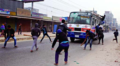 Jamaat-Shibir activists wearing black dress vandalizing a passenger bus in Gazipur area on the first day of their 2-day hartal protesting death penalty of Azharul Islam on Wednesday.