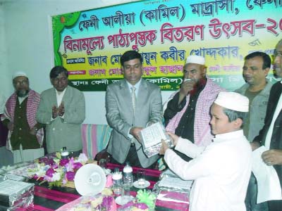 FENI: Md Enamul Haque, ADC(General) Feni distributing free text books at the Textbook Distribution Festival as Chief Guest at Feni Aliaya(Kamil) Madrasa premises yesterday. Principal of the Madarasa Md Mahmudul Hasan presided over the programme.