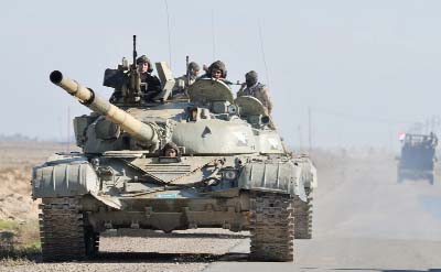 Iraqi soldiers ride on a tank at the outskirt of Balad, north of Baghdad .