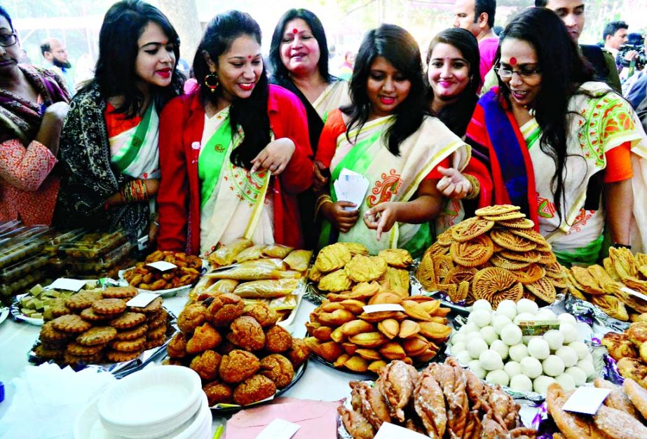 Visitors and organisers at a stall of a 3-day 'Poush Mela' organised by 'Poush Mela Udjapon Parishad' in the city's Ramna Batamul on Friday. Different types of cakes were exhibited in the mela.