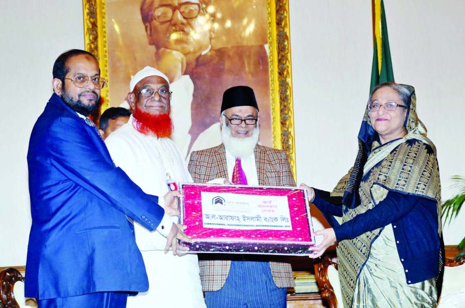 Prime Minister Sheikh Hasina receiving blankets from Md Habibur Rahman, Managing Director and Abdul Malek Mollah, Director of the Al- Arafah Islami Bank Limited to PM's Relief and Welfare Fund for distributing among the cold affected people of the countr