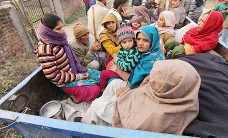 Villagers sit in the back of a vehicle as they flee their homes fearing firing from the Pakistan side of the border at Bainglad village in Samba sector.