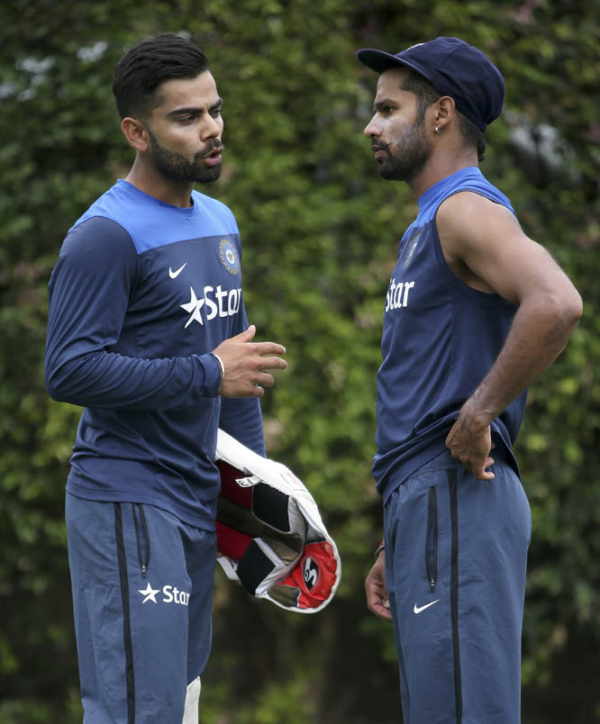 India's captain Virat Kohli (left) and teammate Shikhar Dhawan talk during training for their cricket Test match against Australia in Sydney on Monday. Their final Test of the series begins on Jan. 6 with Australia leading the series 2-0.