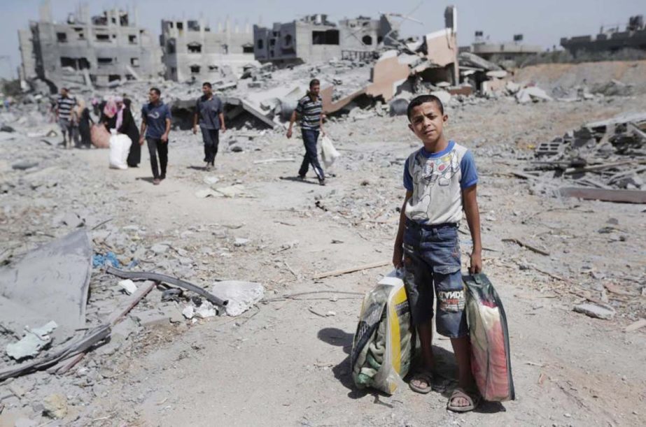 File photo shows Palestinians carry their belongings after salvaging them from their destroyed house in the heavily bombed town of Beit Hanoun, Gaza Strip, close to the Israeli border.