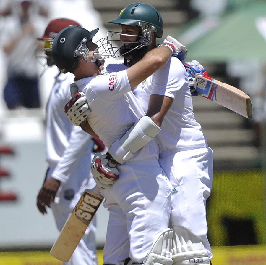 Dean Elgar and Hashim Amla embrace as they secure victory against West Indies on 5th day of 3rd Test at Cape Town on Tuesday.